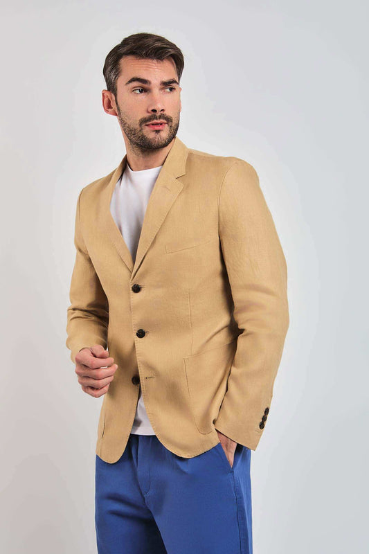Man wearing tan blazer over white shirt and blue pants, stylish men's casual outfit