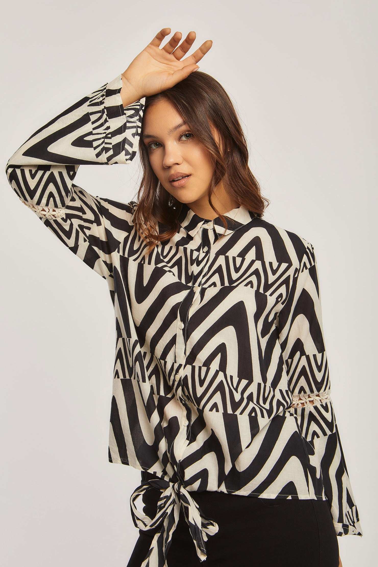 Woman wearing Dalydress black and white patterned blouse, urban fashion, studio setting