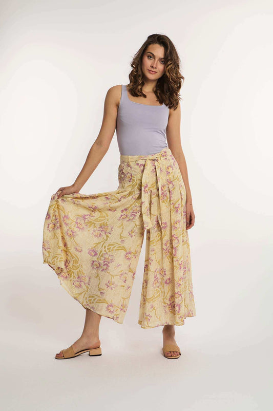Woman wearing a lilac tank top and floral wide-leg pants from Dalydress against a white background