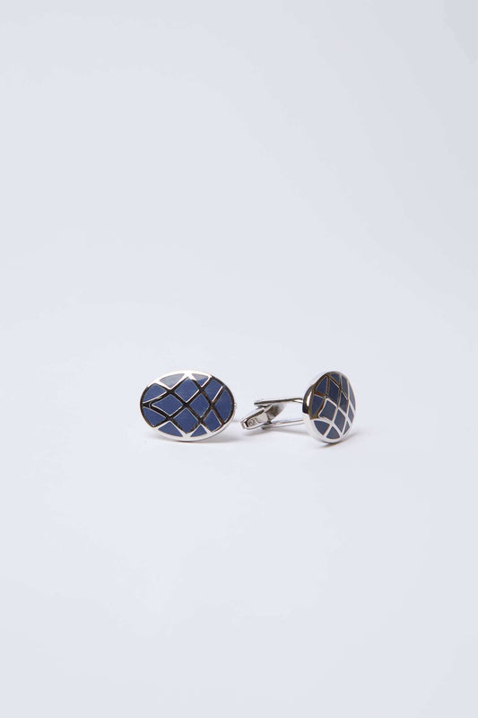 Oval silver cufflinks with dark blue geometric pattern on white background