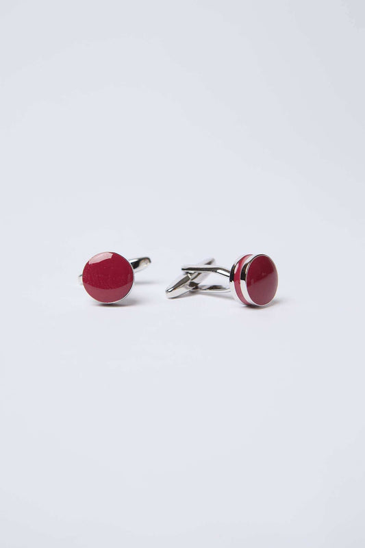 Pair of round red and silver cufflinks on a plain white background