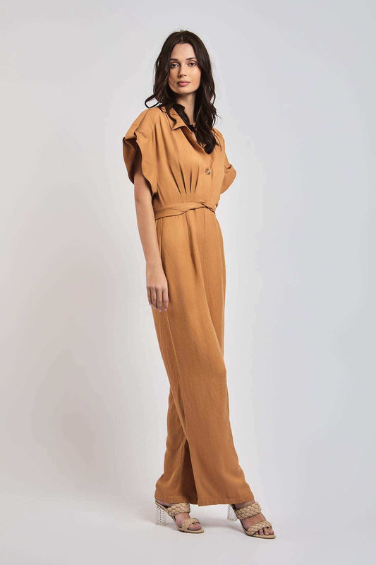 Woman wearing a stylish light brown jumpsuit with short sleeves and belted waist