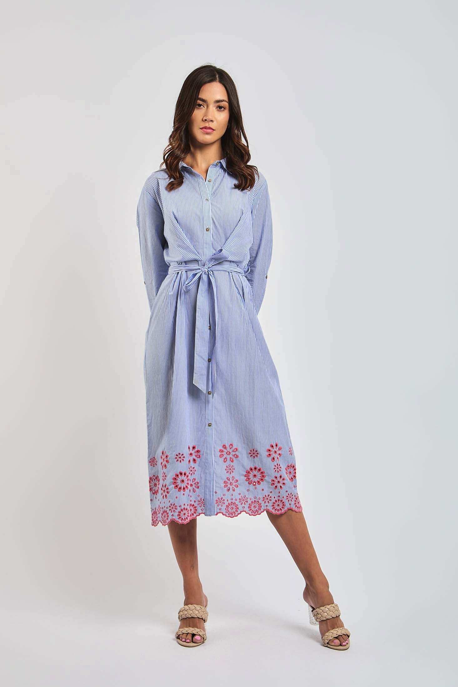 Woman wearing Dalydress blue striped shirt dress with pink floral embroidery, standing indoors