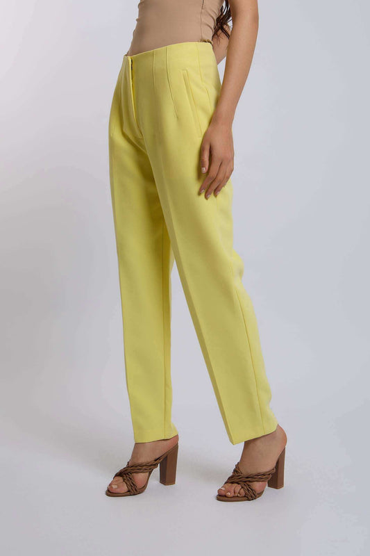 Woman wearing high-waisted yellow tailored pants and brown block heel sandals