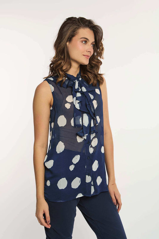 Woman wearing navy blue sleeveless polka dot blouse with neck tie, casual outfit