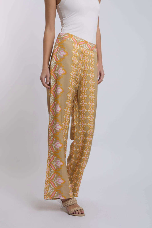 Woman wearing yellow patterned wide-leg pants and white sleeveless top