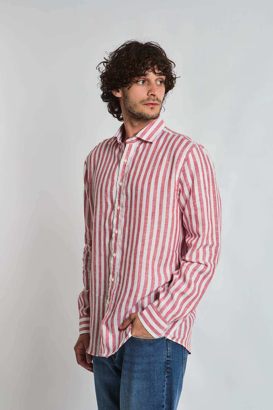 Man wearing Dalydress red and white striped button-up shirt and blue jeans, studio background