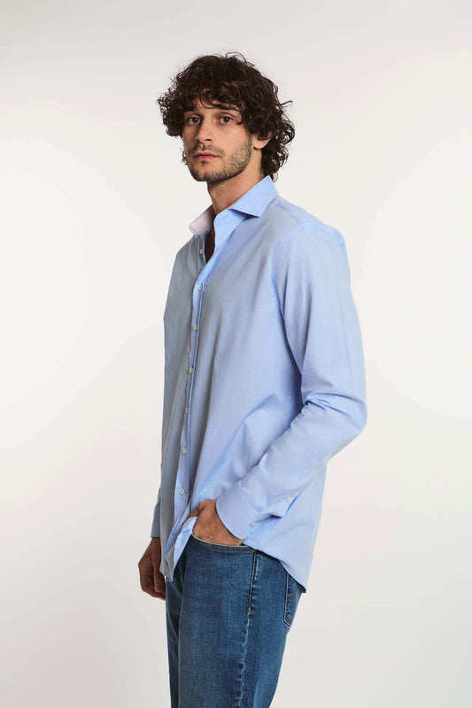 Man wearing a Dalydress light blue button-down shirt and jeans, casual men’s fashion