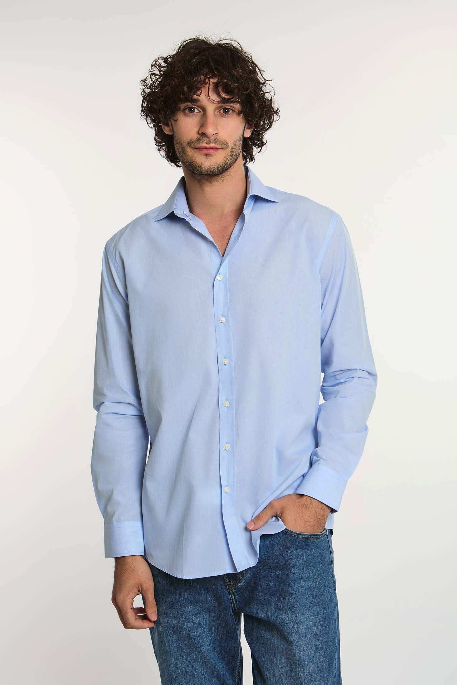 Man wearing light blue Dalydress men's shirt and blue jeans against white background