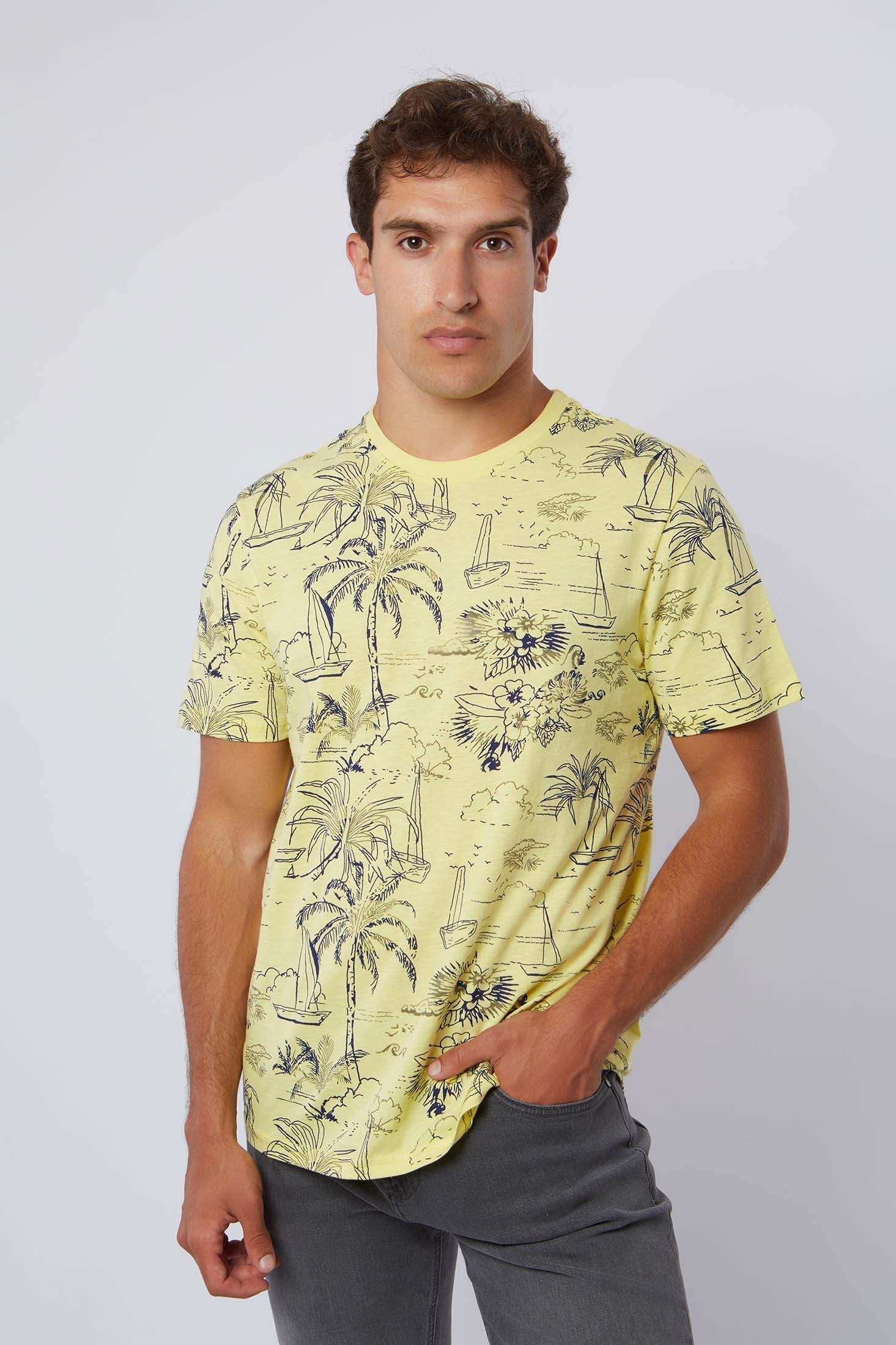 Man wearing yellow Dalydress tropical print t-shirt and grey pants, casual fashion look