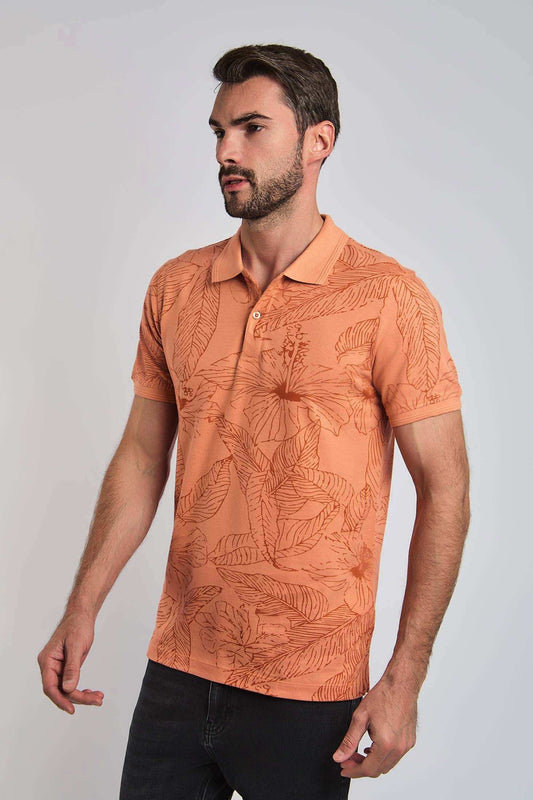 Man wearing orange floral print polo shirt with short sleeves and black pants