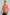 Man wearing orange floral print polo shirt with short sleeves and black pants
