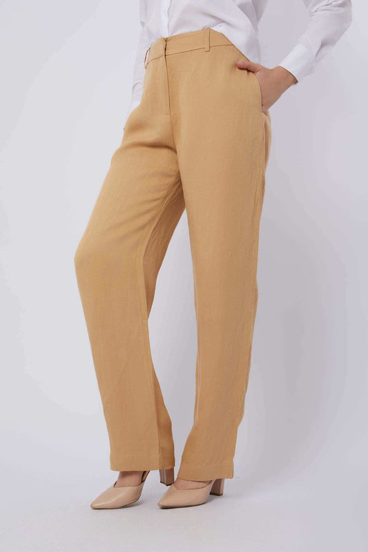 Woman wearing beige straight-leg trousers with pockets and nude heels