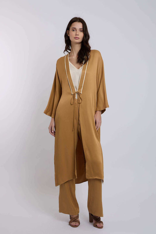 Woman wearing camel brown kimono-style long cardigan with matching wide-leg pants and strappy heels