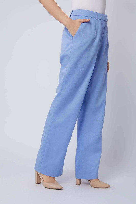 Woman wearing high waist light blue wide leg pants with side pockets and beige heels