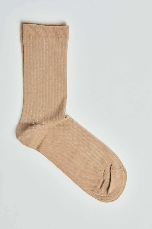 Beige ribbed crew sock on white background, casual men's or women's wear accessory
